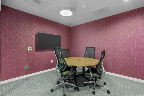 A conference room with a table and chairs.