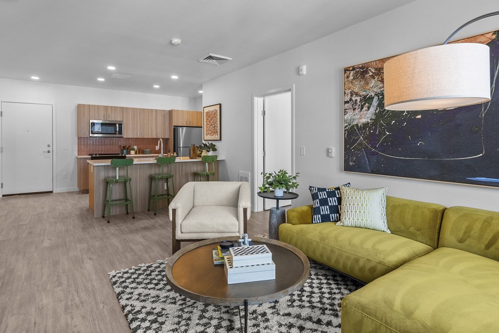 A modern living room with a yellow couch and a coffee table.
