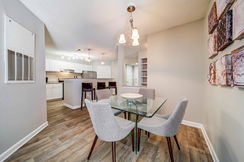 a dining room and kitchen with a glass table and chairs
