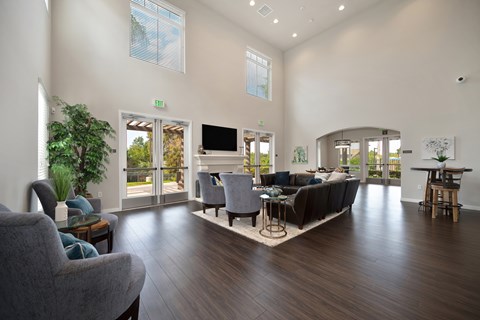 A living room with a grey couch and a wooden floor.
