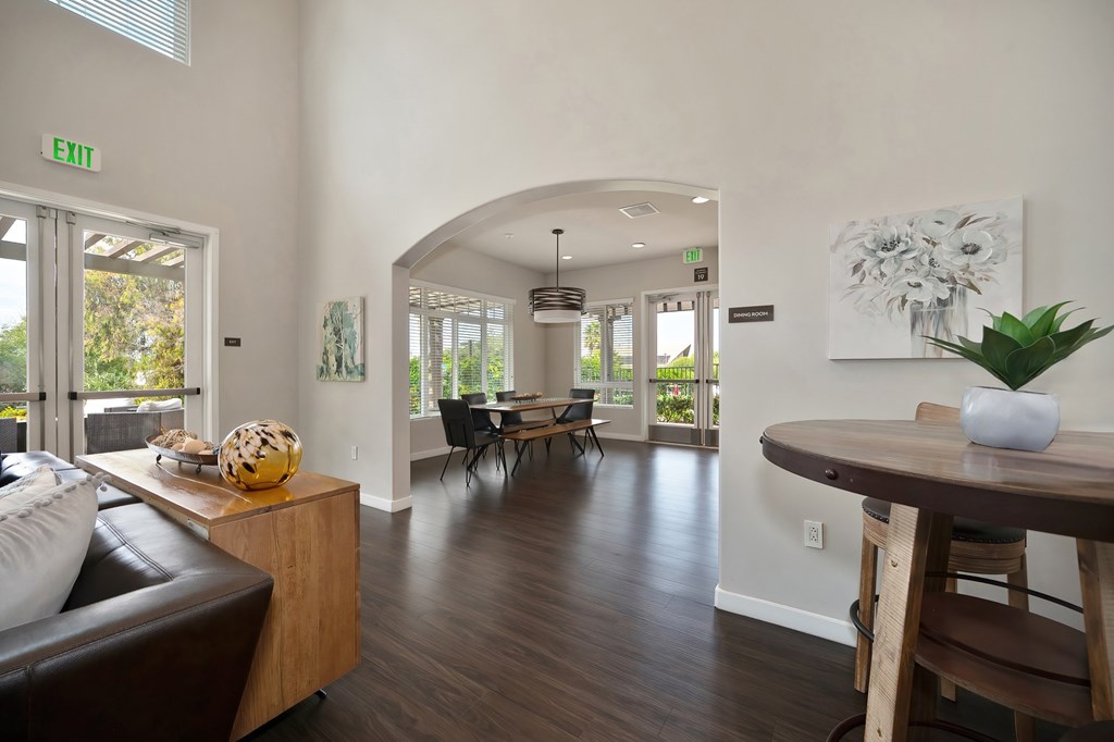 A living room with a brown leather couch and a wooden table.