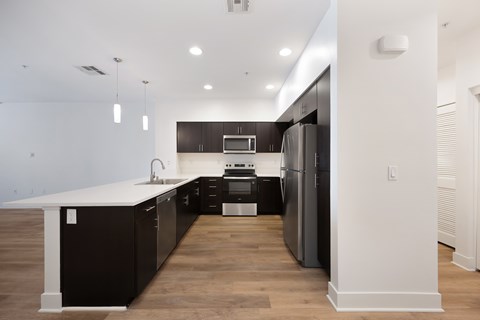 A modern kitchen with dark wood cabinets and stainless steel appliances.