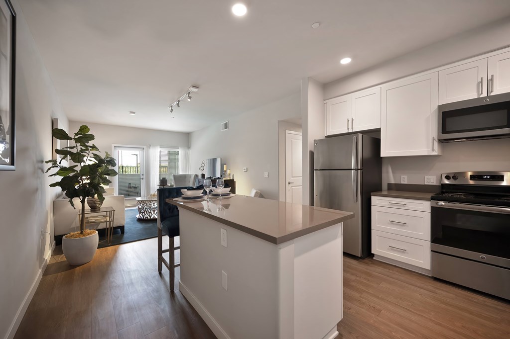 A modern kitchen with white cabinets and stainless steel appliances.