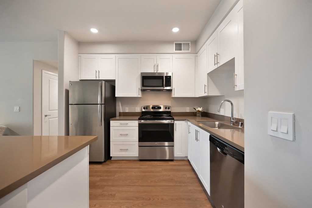 A kitchen with white cabinets and stainless steel appliances.
