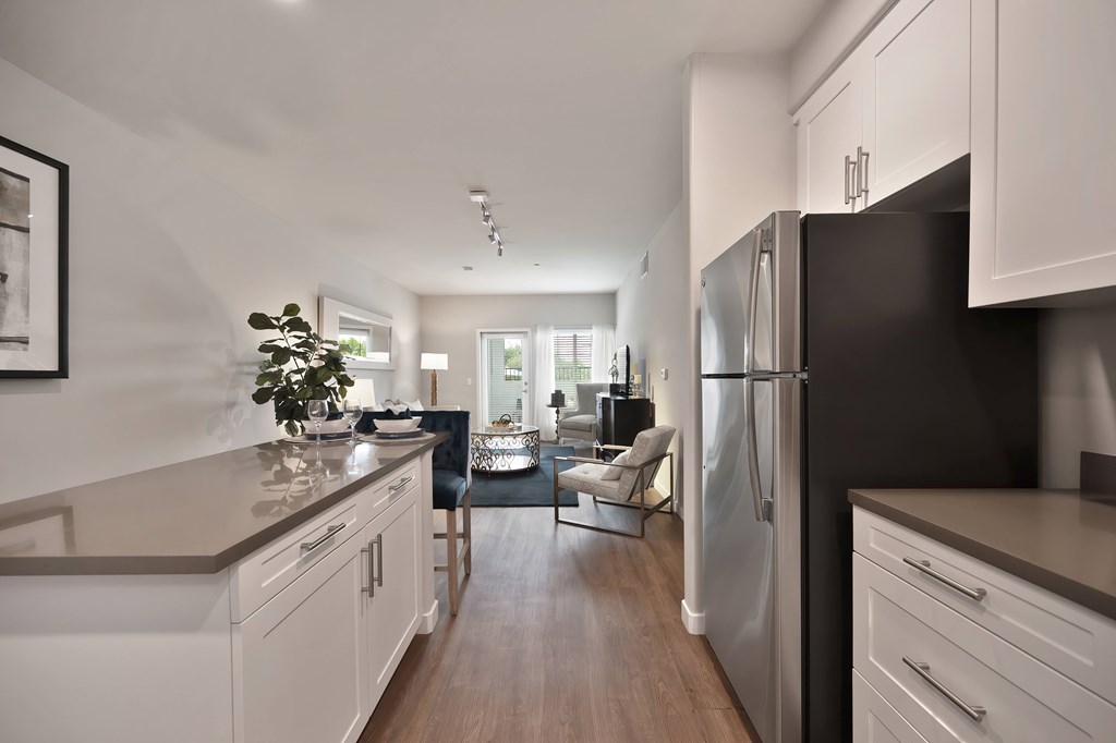 A modern kitchen with white cabinets and a black refrigerator.