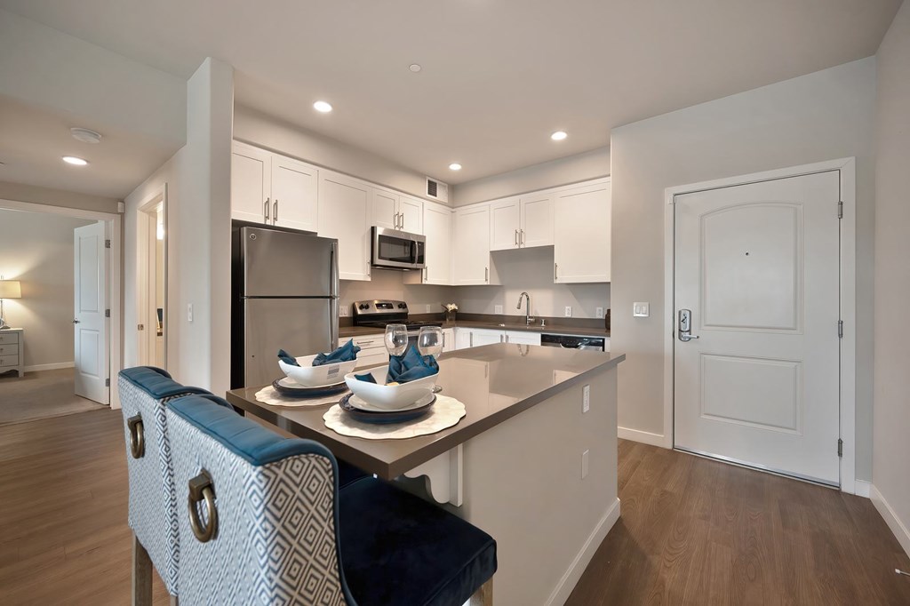 A modern kitchen with a dining table and chairs.