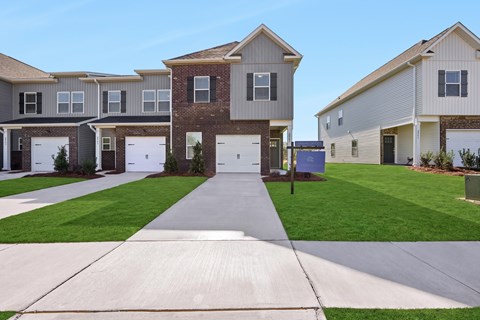 A row of houses with a driveway in the foreground.