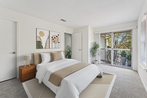 A bedroom with a large bed and a painting on the wall.