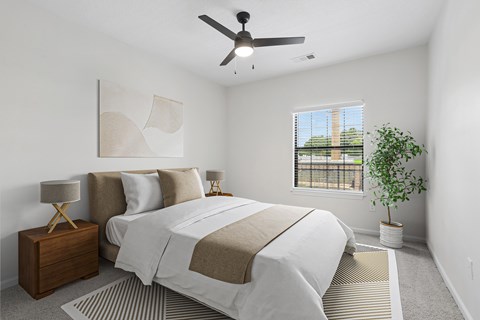 A bedroom with a large bed and a ceiling fan.