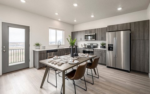 a kitchen with stainless steel appliances and a table with chairs
