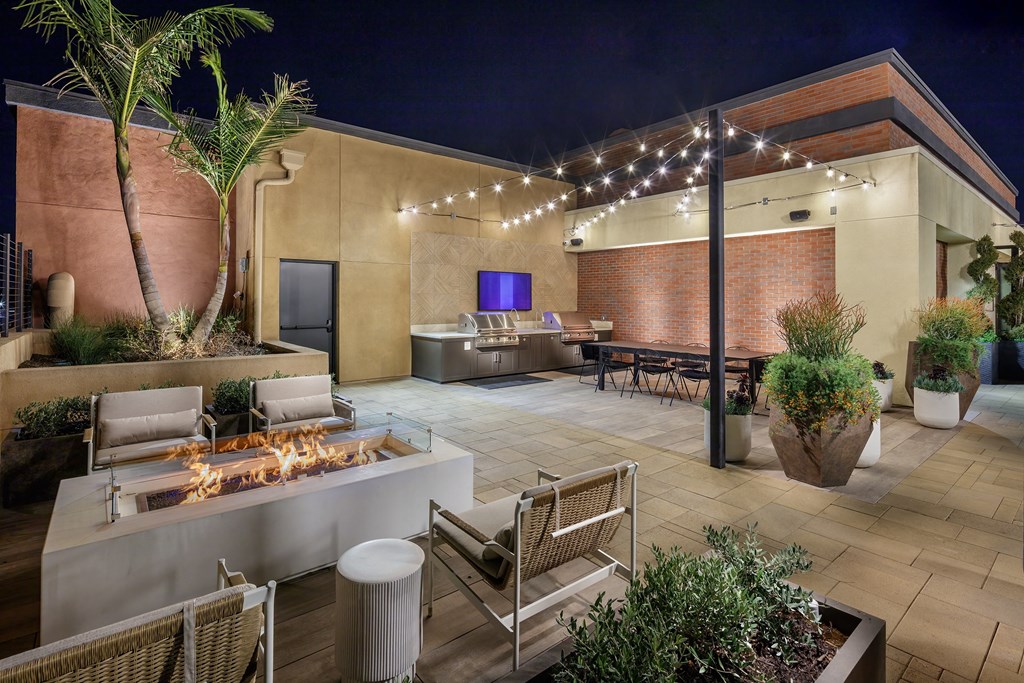 a patio with a fire pit and a bar