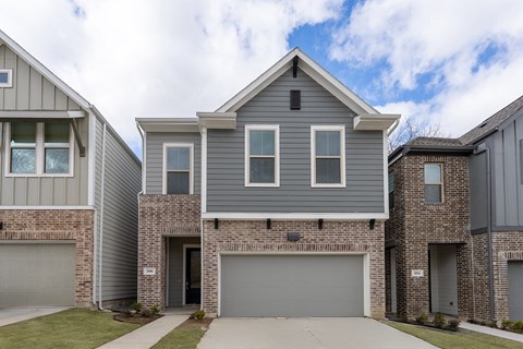 a gray and brick house with a garage