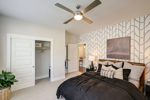 A bedroom with a large bed and a ceiling fan.