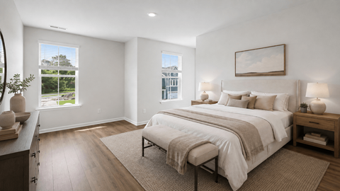 A bedroom with a large bed and a view of a building outside the window.