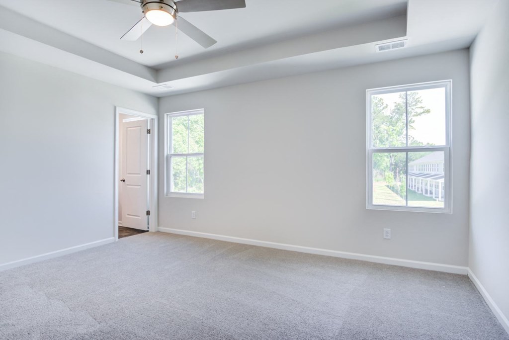 an empty room with a ceiling fan and two windows at Berkeley Homes, Moncks Corner South Carolina