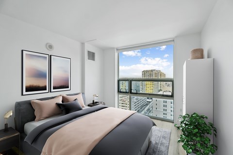 A bedroom with a large bed and a view of the city.