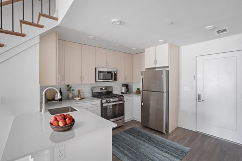a kitchen with white cabinets and stainless steel appliances
