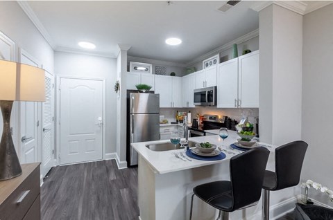 a kitchen with a island and a stainless steel refrigerator