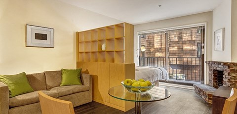 a living room with a couch and a table with a bowl of fruit on it
