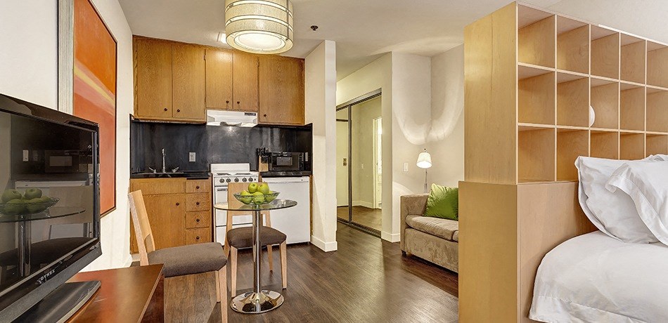 a studio apartment with a kitchen and living room