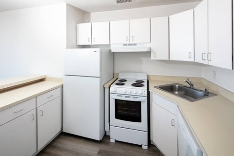 a kitchen with white cabinetry and white appliances