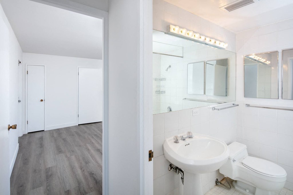 a bathroom with a toilet sink and mirror