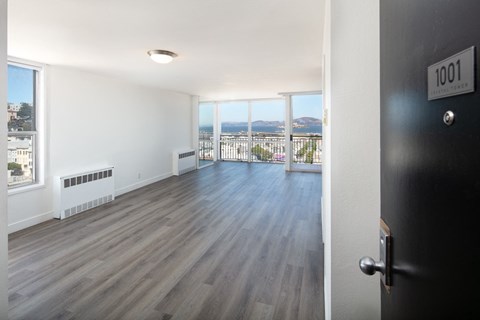 an open living room with hardwood floors and a balcony