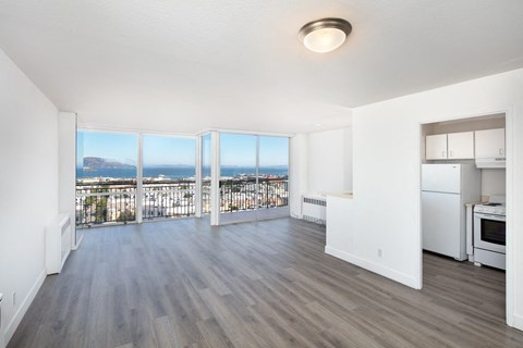 an open living room with a balcony and a view of the city