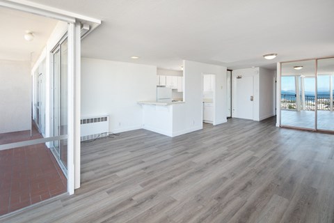 an empty living room with white walls and a wooden floor