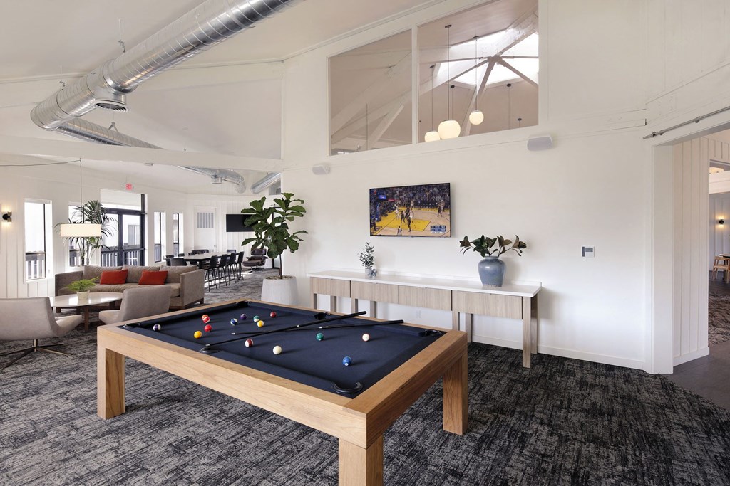 a games room with a pool table in the middle