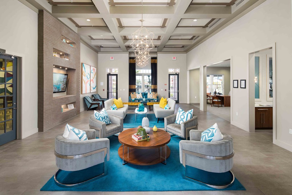 A large, modern living room with a blue rug and grey couches.
