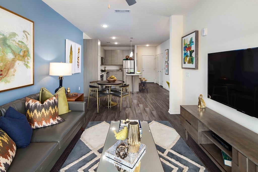 A living room with a grey couch and a coffee table in the middle.