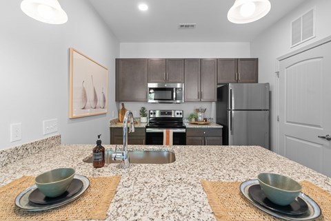 A kitchen with a granite countertop and a sink.