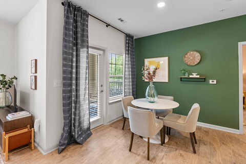 A dining room with a table set for four.