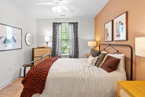 A bedroom with a large bed and a ceiling fan.