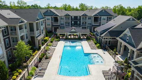 A large swimming pool surrounded by apartment buildings.