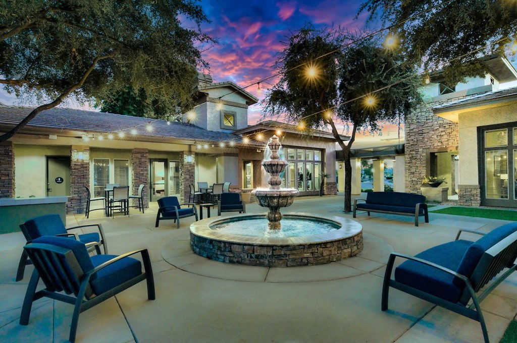 A beautifully lit patio with a fountain at the center.