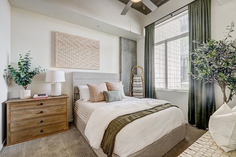 a bedroom with a bed and a large window
