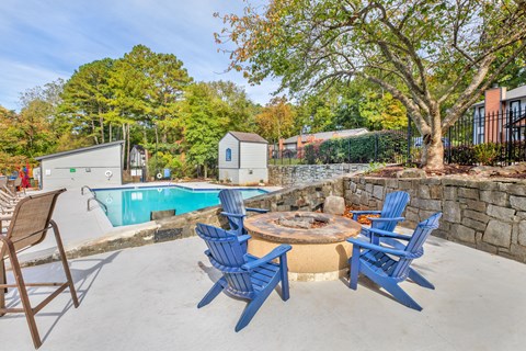 A pool with a table and chairs around it.