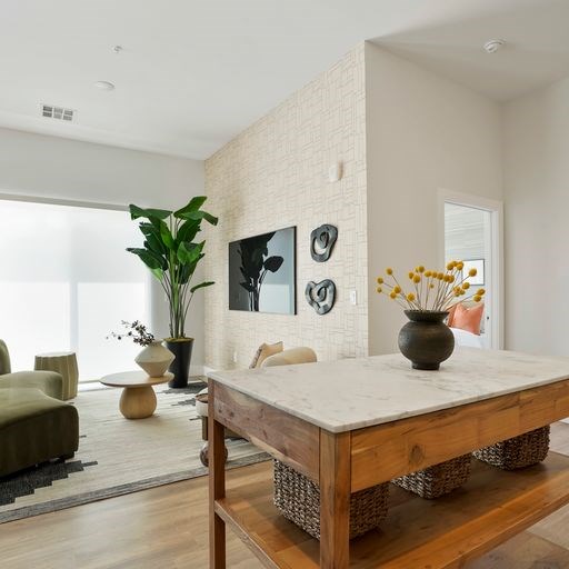 A modern living room with a wooden coffee table and a large window.