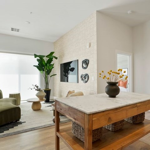 A modern living room with a wooden coffee table and a large window.