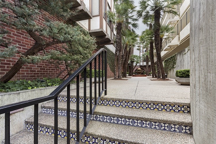 a staircase with a black railing leading up to an apartment building