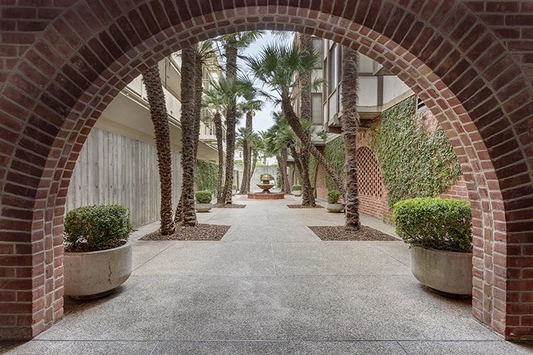 a courtyard with palm trees and a fountain