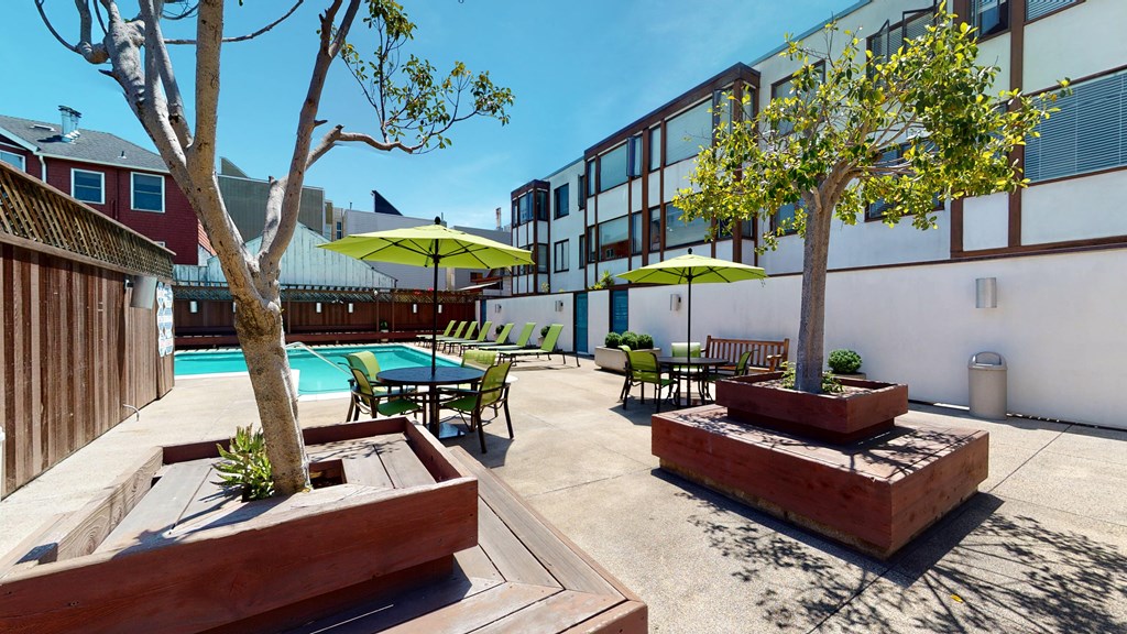 a patio with a pool and chairs and umbrellas