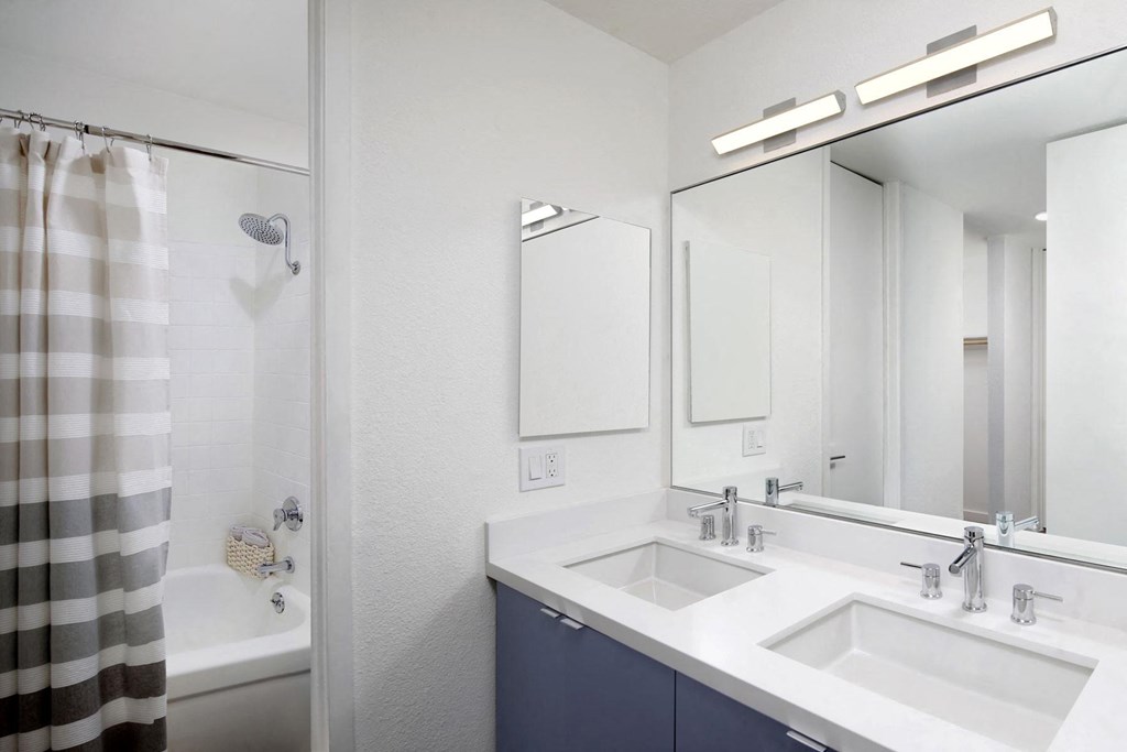 a bathroom with two sinks and a shower and a mirror