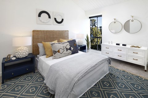 a bedroom with a bed and two mirrors on the wall