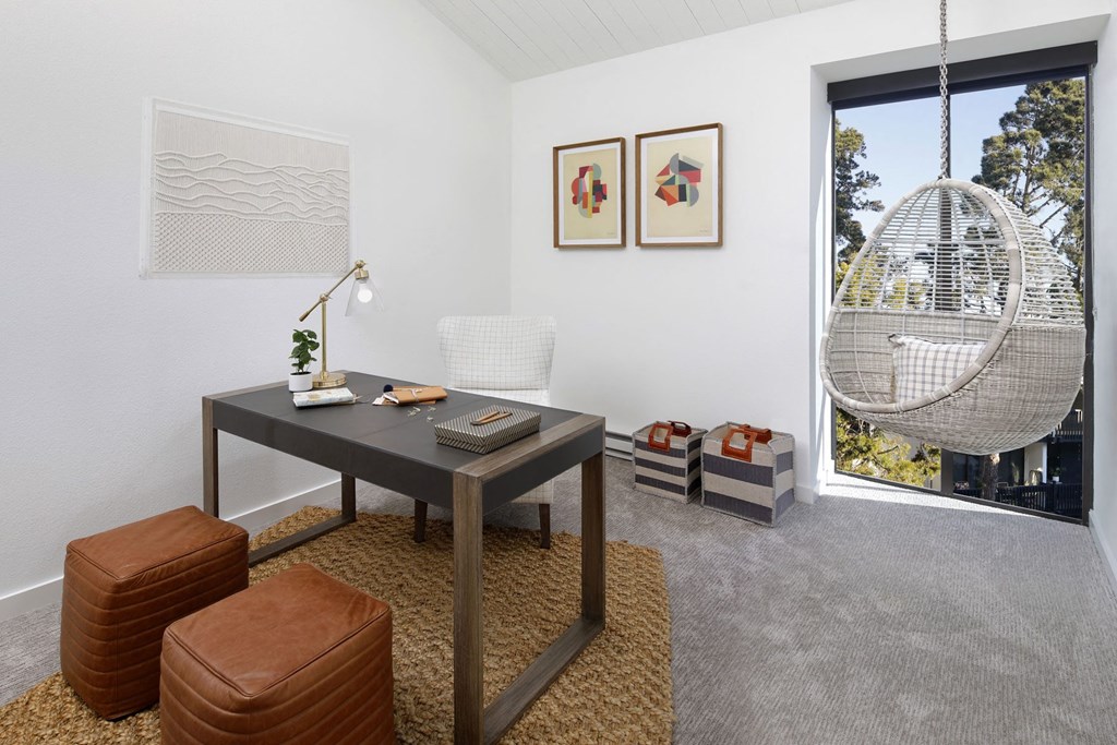 a living room with a table and a chair and a window