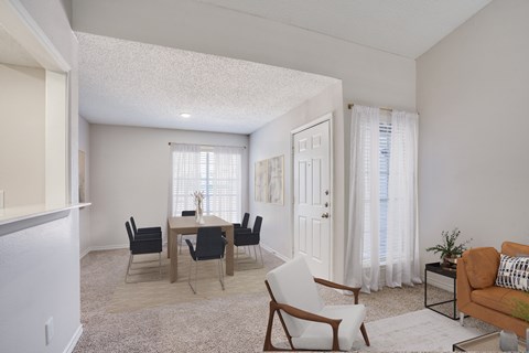A living room with a dining table and chairs.