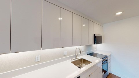 a kitchen with white cabinets and a stainless steel sink