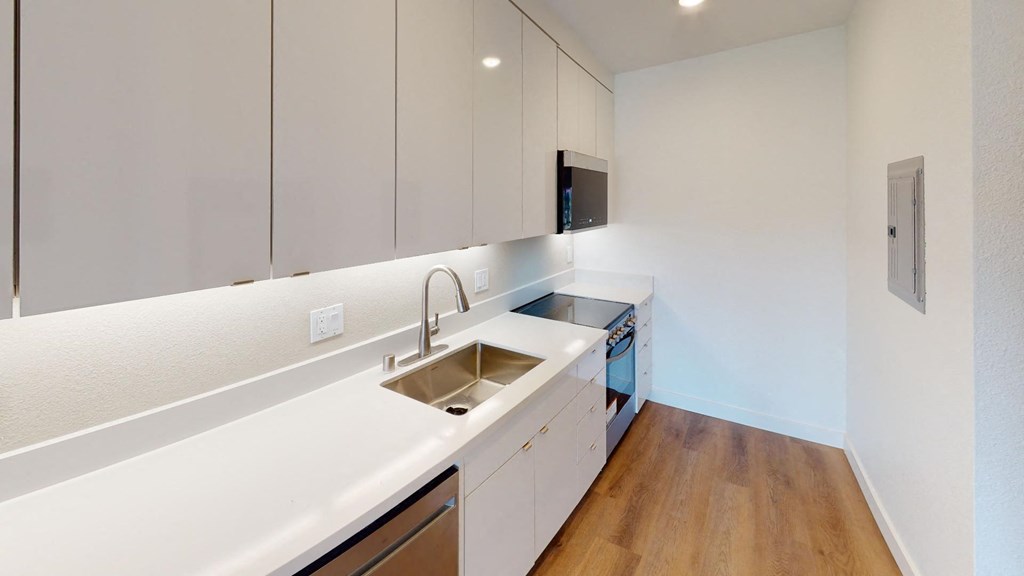 a kitchen with white cabinets and a stainless steel sink